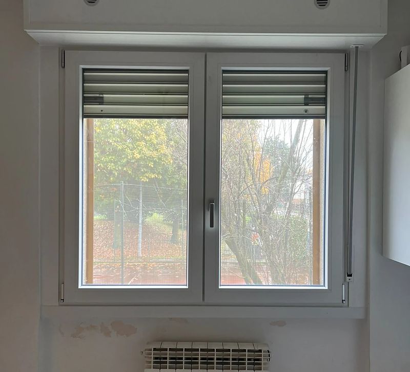 Finestra in PVC bianco a due ante con tapparella.