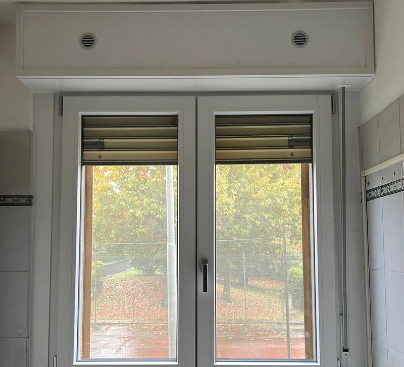 Finestra in PVC bianco con cassonetto, in un bagno.