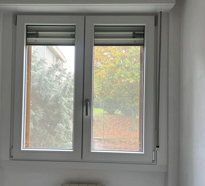 Finestra in PVC bianco con cassonetto, in una cucina.